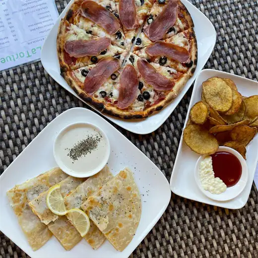 Pizza, fries, and quesadilla at La Tortue dining